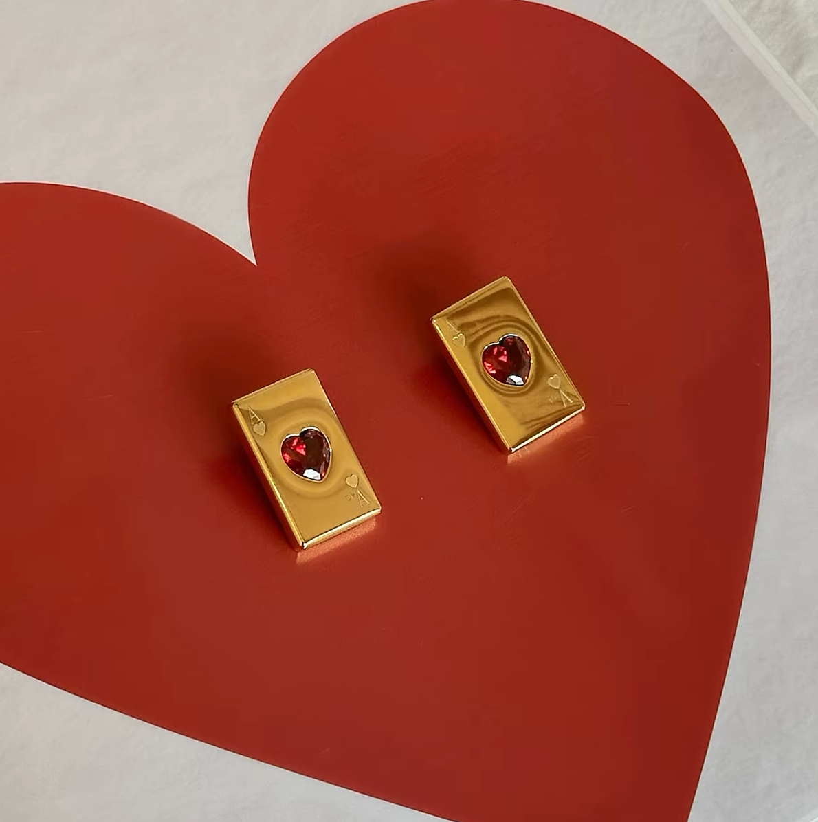 Pair of gold-plated Ace of Hearts stud earrings with rectangular card design and red heart-shaped gemstones