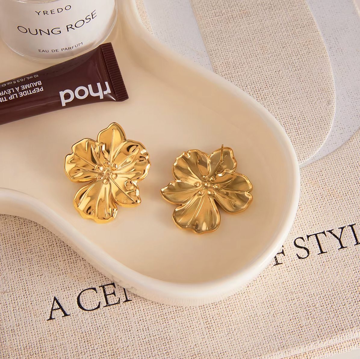 Gold-plated flower-shaped stud earrings with sculpted petals and a polished finish