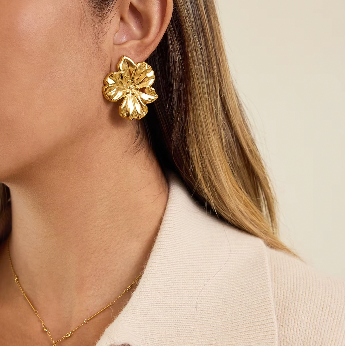 Gold-plated flower-shaped stud earrings with sculpted petals and a polished finish
