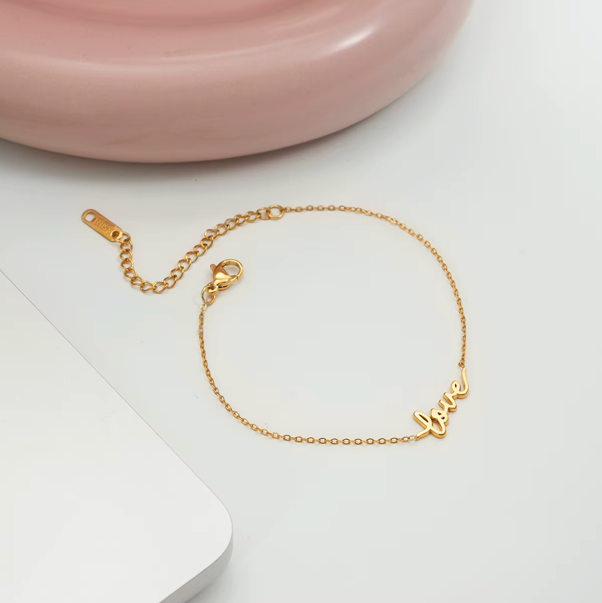 Gold-plated bracelet with a delicate chain and “love” script charm