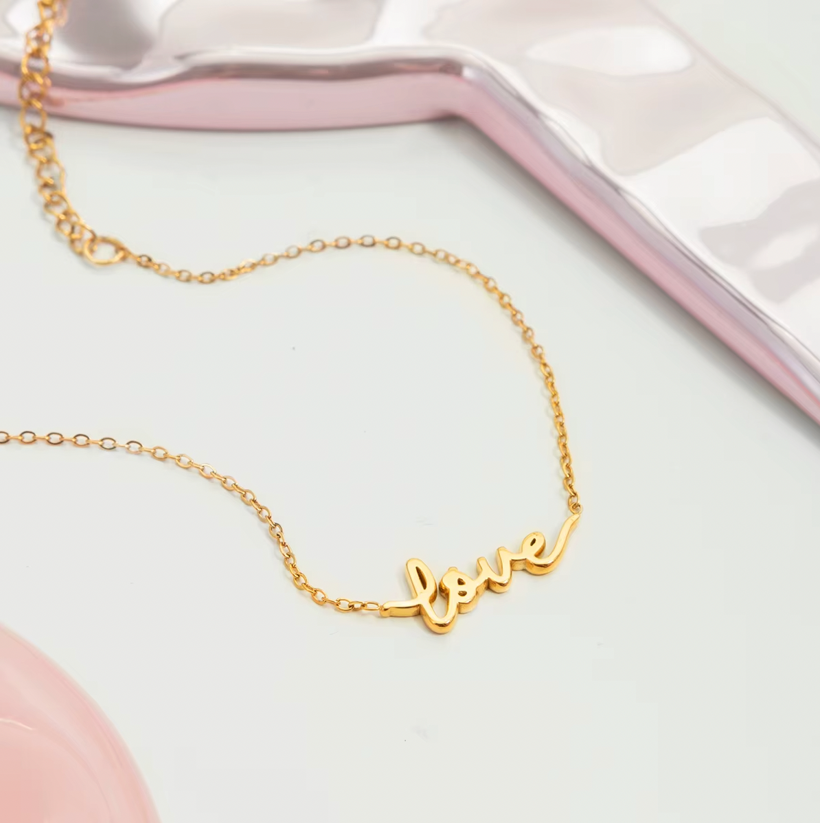 Gold-plated bracelet with a delicate chain and “love” script charm