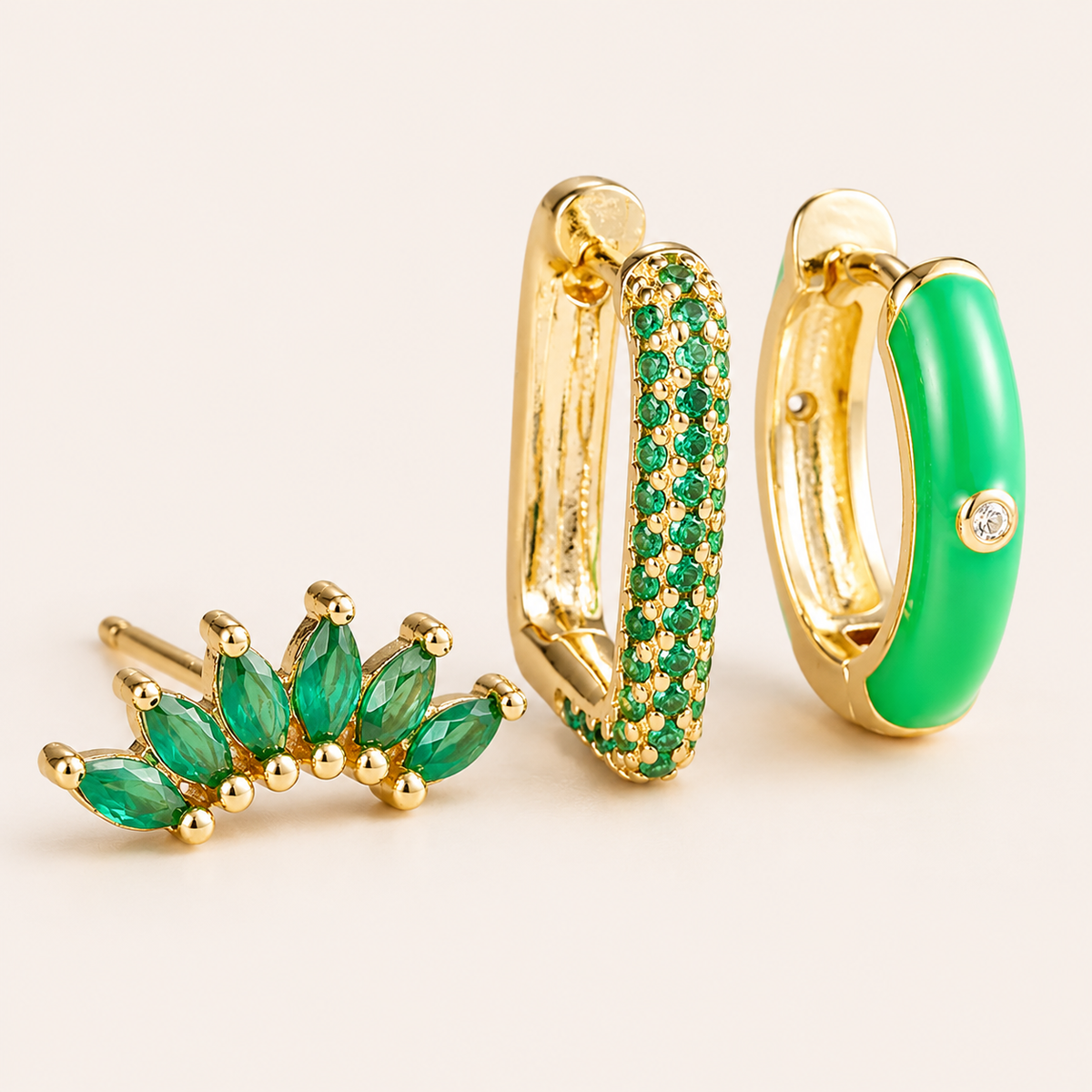 Three-piece Ames SET gold earrings in green: a marquise ear climber, a pave hoop, and a green enamel hoop with a stone accent.