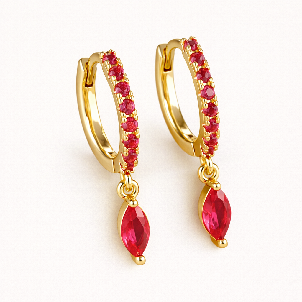 Anette Earrings in gold with ruby-red crystals, the pave huggie hoop dropping a marquise-cut red charm.