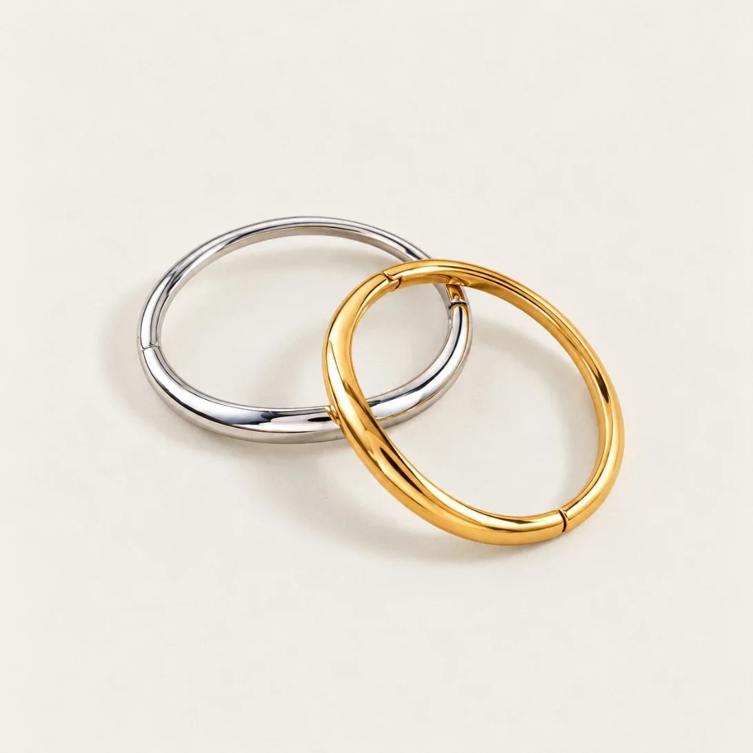 Gold and silver-tone Arco BRACELETS interlocked, smooth oval bangles on a cream background — Folie à Trois