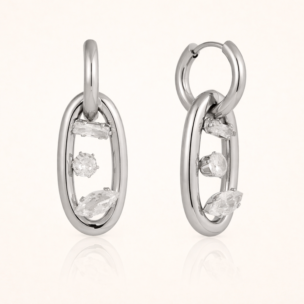 The Astral EARRINGS are shown in polished silver, pairing an open hoop with a crystal-set oval link charm.
