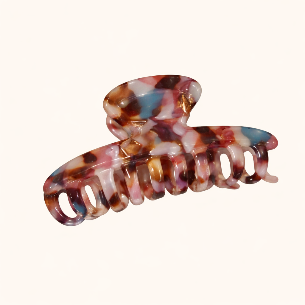 Pink, blue and brown speckled tortoiseshell acetate claw clip from the Baby Love HAIR CLIP collection, on a cream studio background.