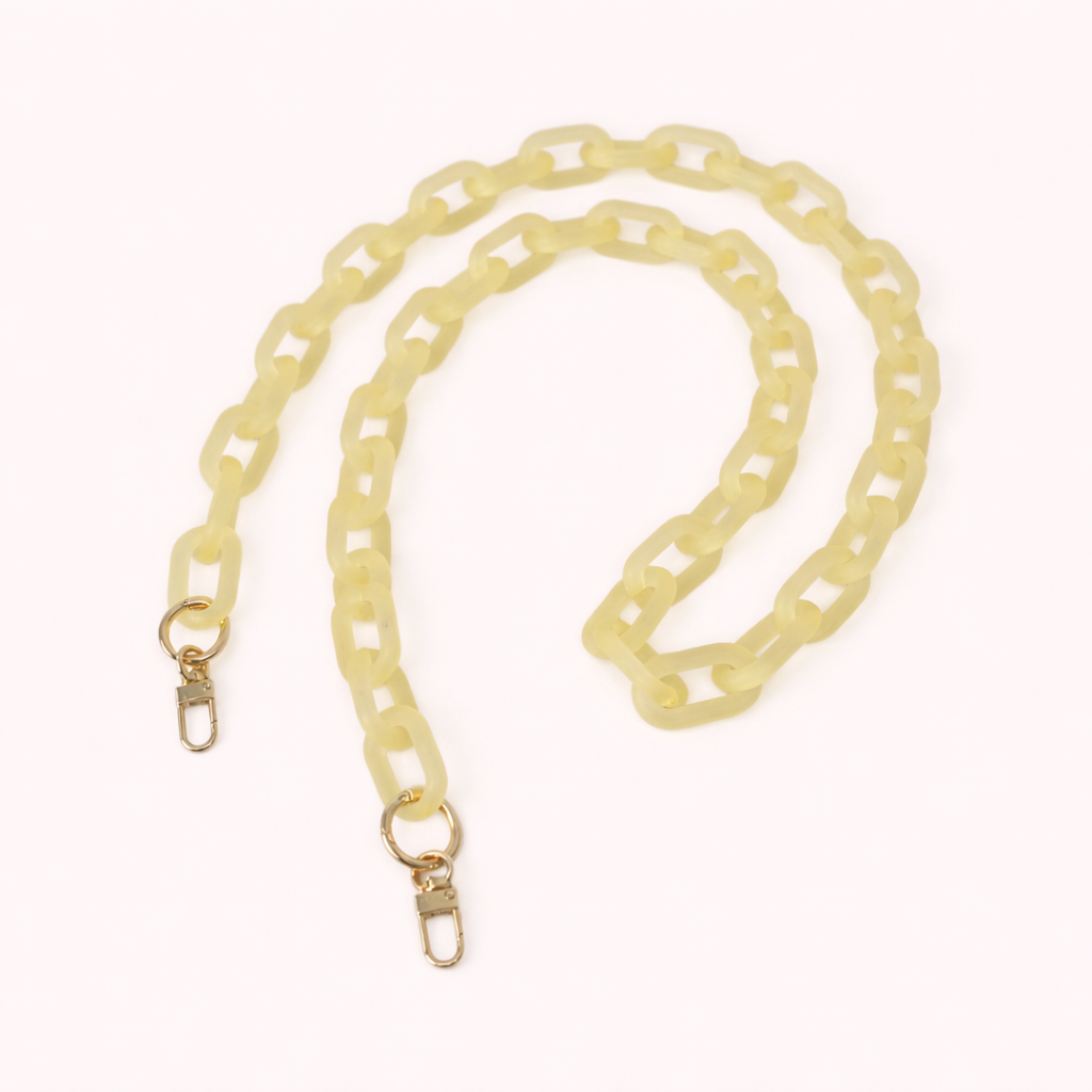Pale yellow frosted acrylic Bubble Links phone chain coiled flat with gold-tone clasp hardware.