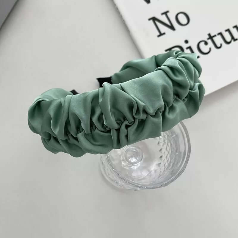 Sage green ruched satin headband styled on a glass tumbler, from a generic headband catalog set.