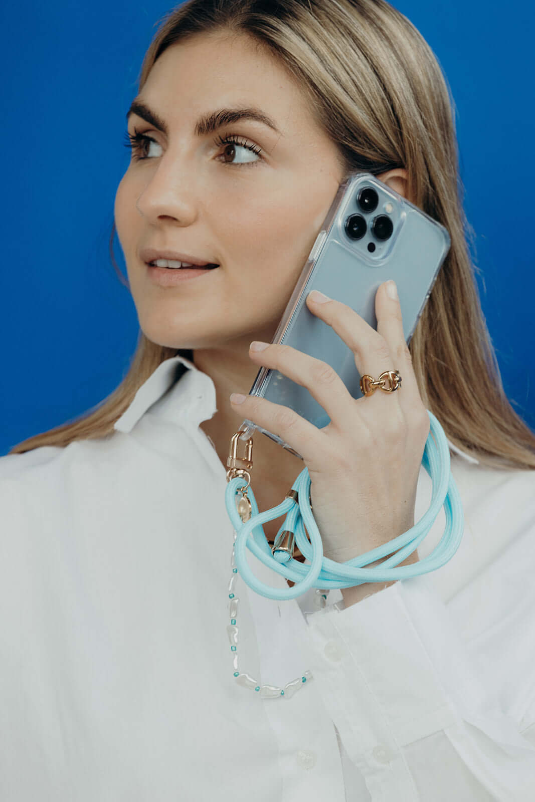 Light blue Colorful PHONE CORD, model on a phone call against a bright blue background.