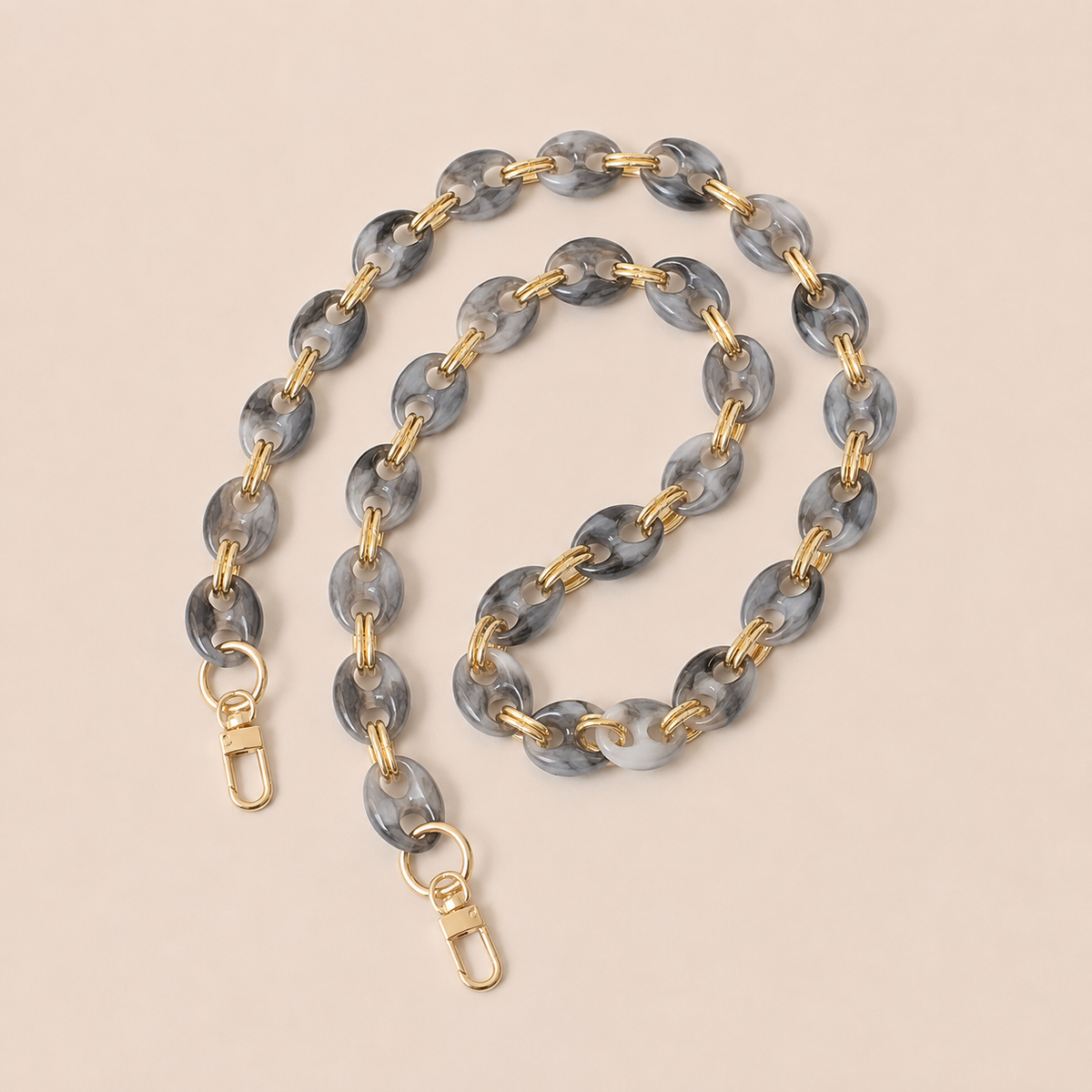 Charcoal marbled coin-link phone chain with gold connectors coiled on cream — Folie à Trois Corvin long phone chain