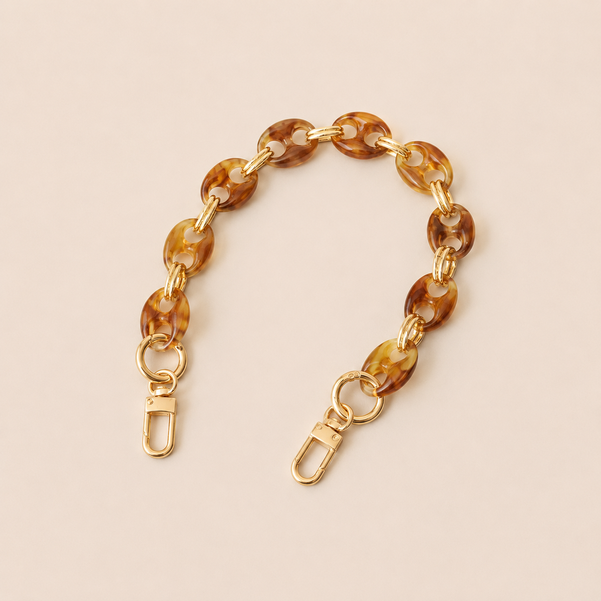 Round light brown tortoiseshell coin-link phone chain with gold connectors on cream — Folie à Trois Corvin short phone chain