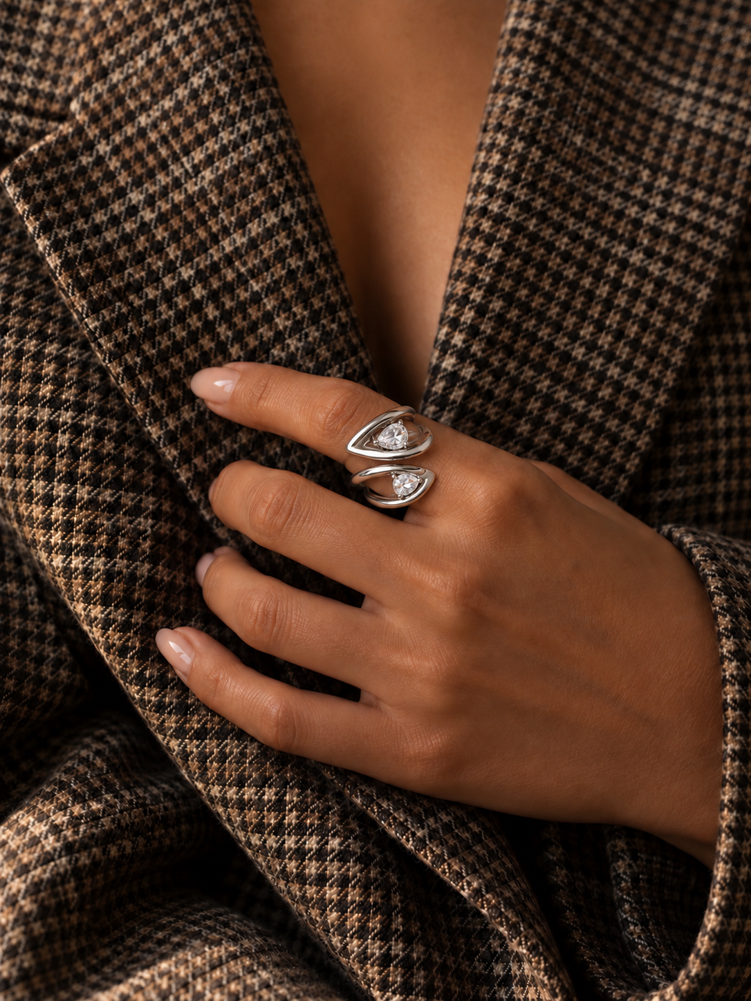 Hand on a houndstooth blazer wears the silver-tone Croisé RING, crossed bands set with white zirconia — Folie à Trois wholesale