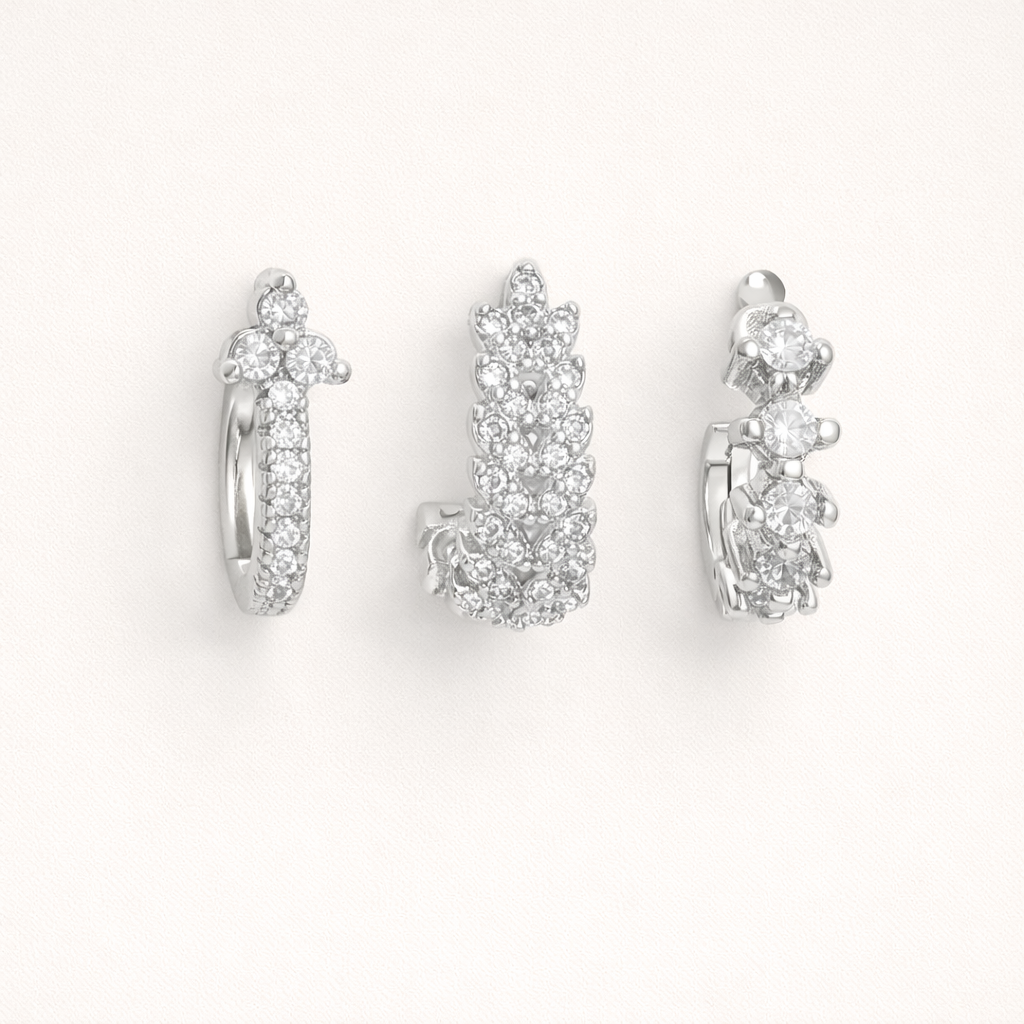 Daisy Set in silver tone, a pave hoop with a flower cluster top, a fully pave leaf-shaped hoop, and a graduated stone hoop.