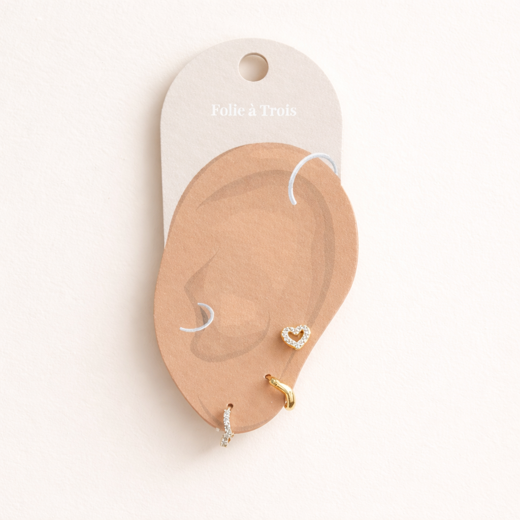 Illustrated Folie a Trois earring card showing the Delia Set pieces arranged on an ear-shaped display.