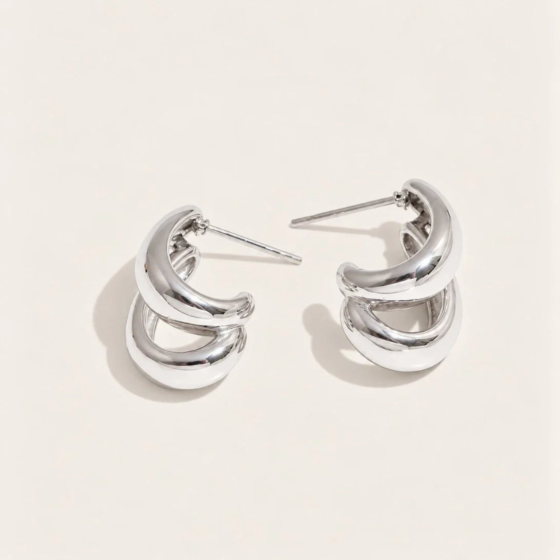 Silver-tone Doppia EARRINGS: a pair of hoops formed by two smooth C-shaped curves layered together — Folie à Trois