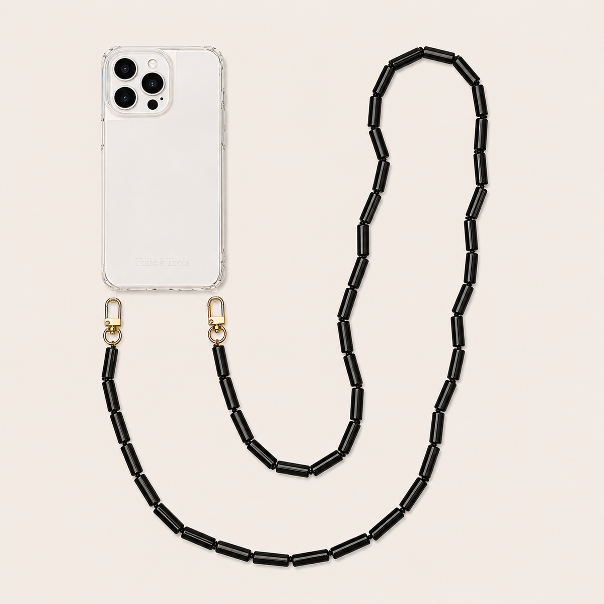Black tube-bead phone chain clipped to a clear iPhone case on a cream background — Folie à Trois Elowen wholesale phone chain