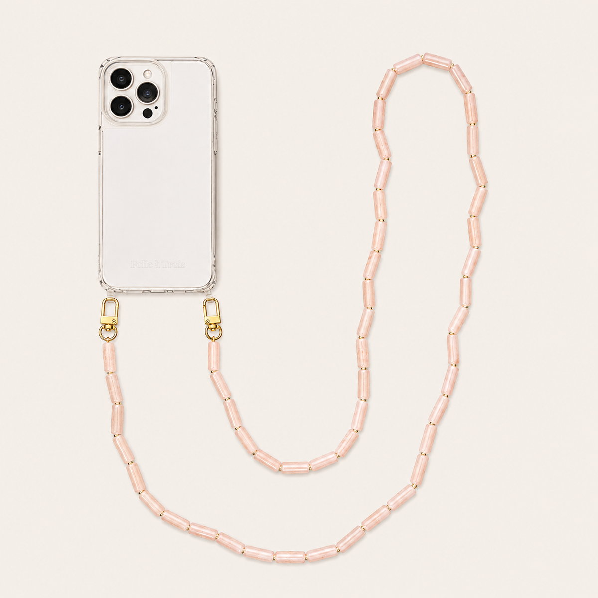 Peach tube-bead phone chain clipped to a clear iPhone case on a cream background — Folie à Trois Elowen wholesale phone chain