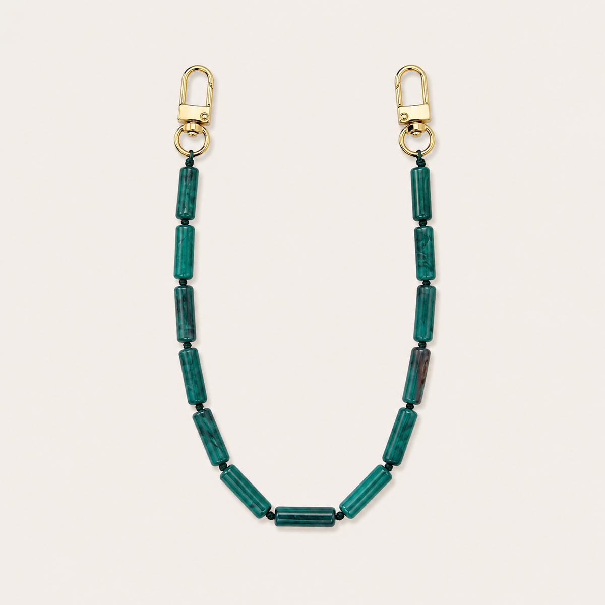 Teal green tube-bead phone chain with gold lobster clasps laid flat on cream — Folie à Trois Elowen wholesale phone chain