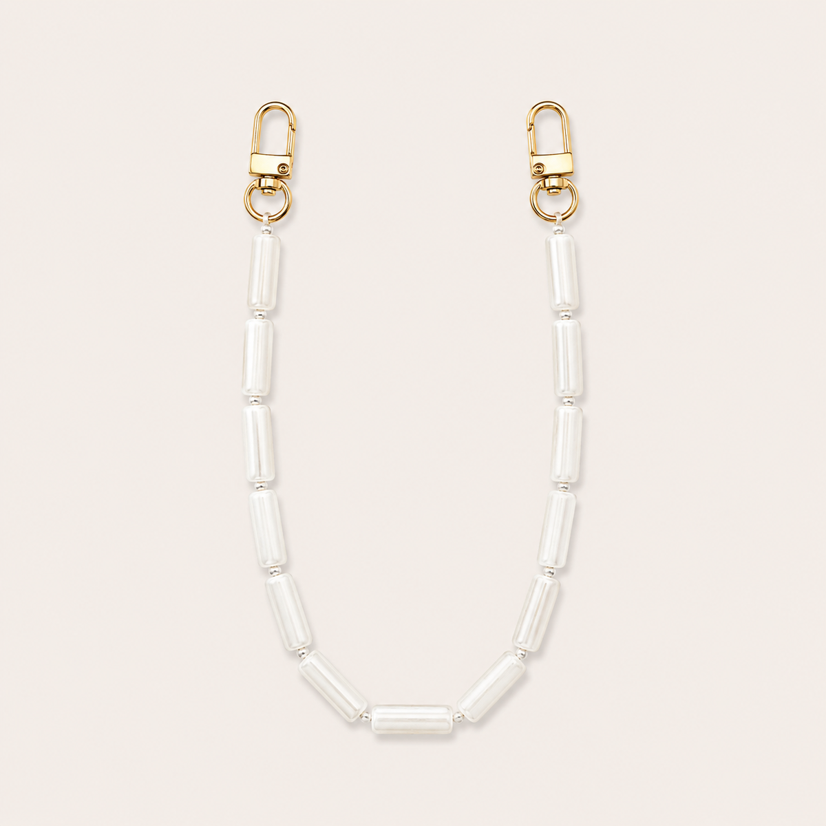 White pearl tube-bead phone chain with gold lobster clasps laid flat on cream — Folie à Trois Elowen wholesale phone chain