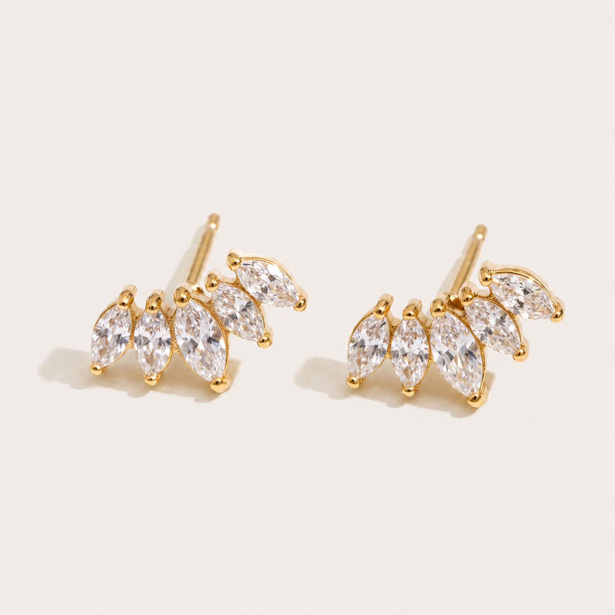 Gold marquise-cut zirconia climber studs fanned in a cluster on a cream backdrop — Folie à Trois Facet EARRINGS