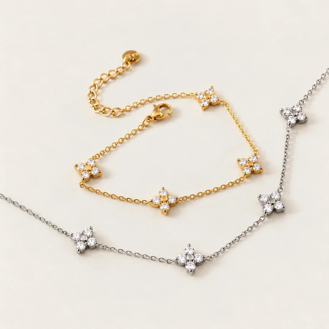 Gold Fiore BRACELET with zirconia flowers beside a silver-tone Fiore necklace on a cream background — Folie à Trois