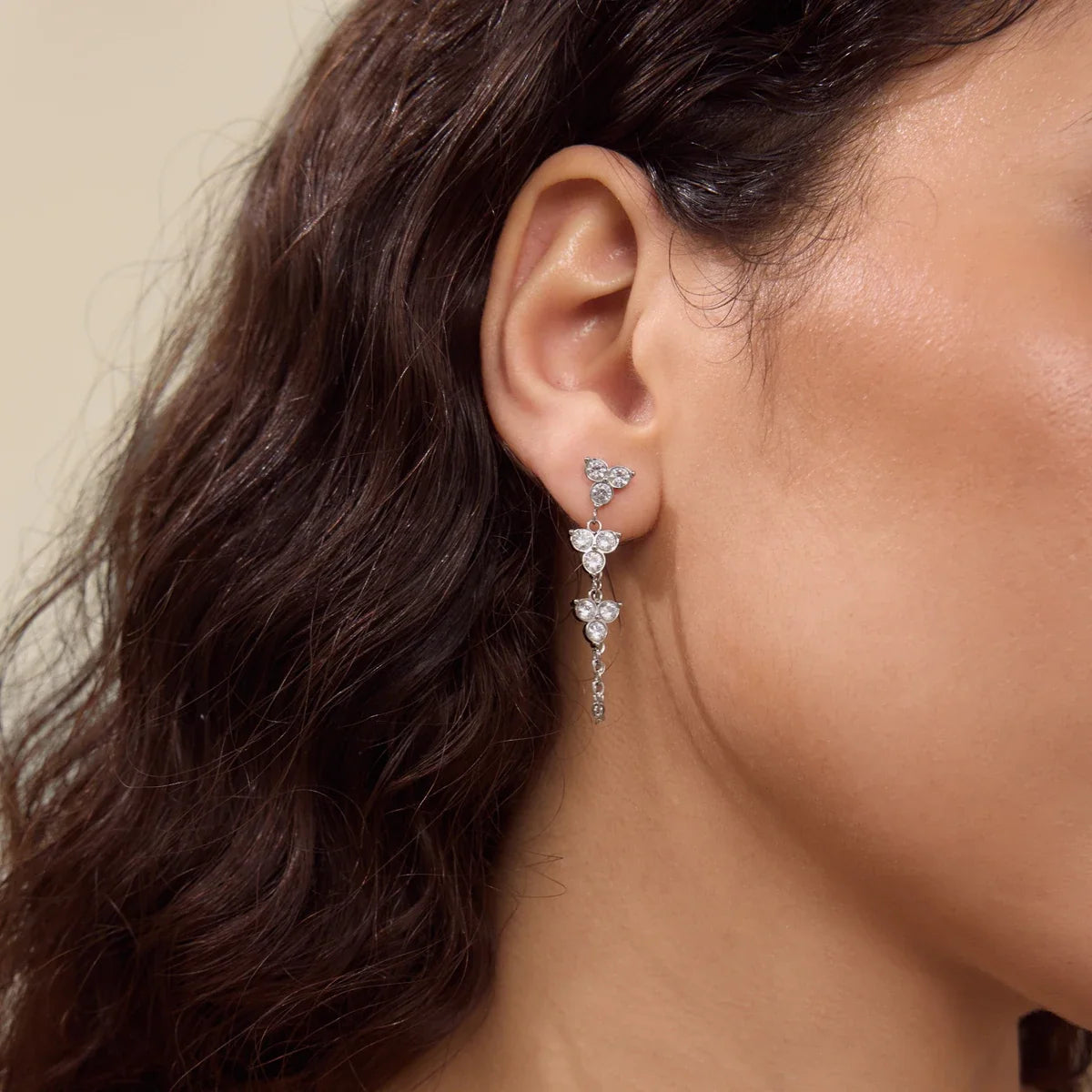 Silver-tone Fiore EARRINGS worn by a model with wavy brown hair, sparkling zirconia trefoil drops — Folie à Trois