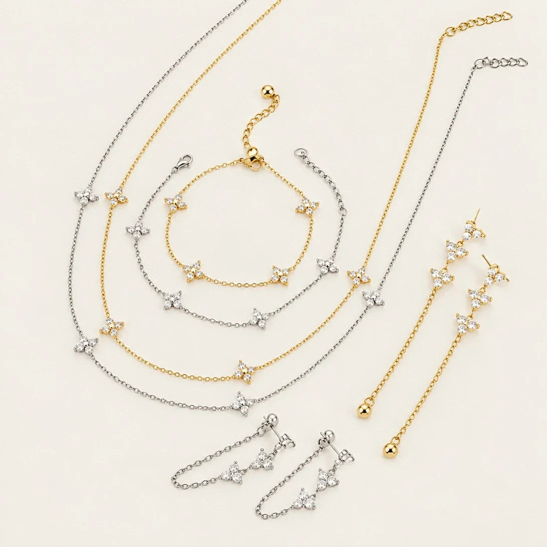 Fiore collection flat lay: gold and silver-tone flower necklaces, bracelets and chain earrings — Folie à Trois jewelry