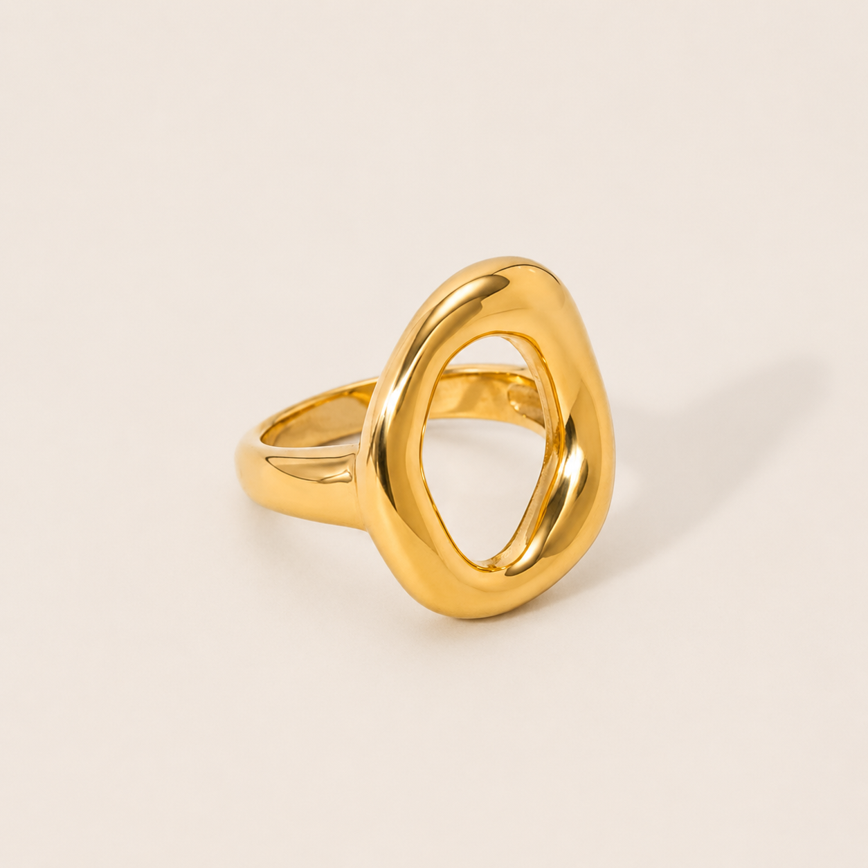 Gold Formentera RING with an open, asymmetric organic loop and a chunky polished band, shown in close-up on a cream backdrop.