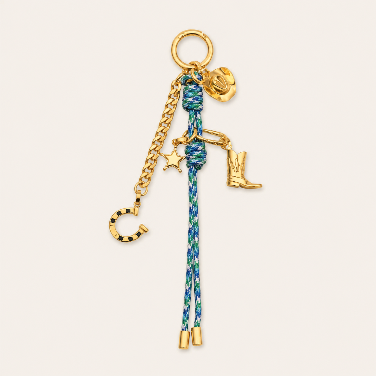 Folie à Trois Fortuna BAG CHARM, a blue-and-green rope charm with gold cowboy boot, hat, horseshoe, and star charms on a hoop clasp.