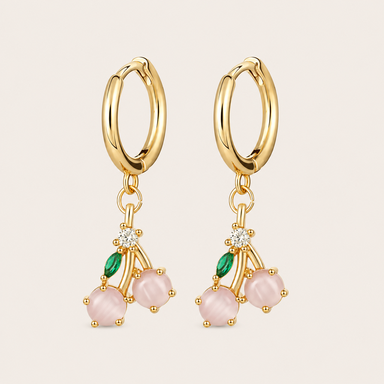 Gold hoop earrings from the Fruit Hoop EARRINGS with a cherry charm of two pink cabochon stones, a green leaf, and a white accent stone.