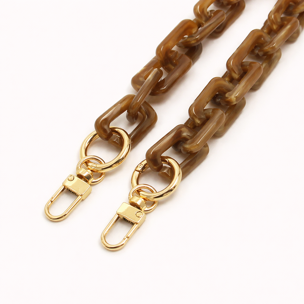 Close-up of the gold clasps on an olive brown marbled acrylic paperclip-link phone chain, on a white background.