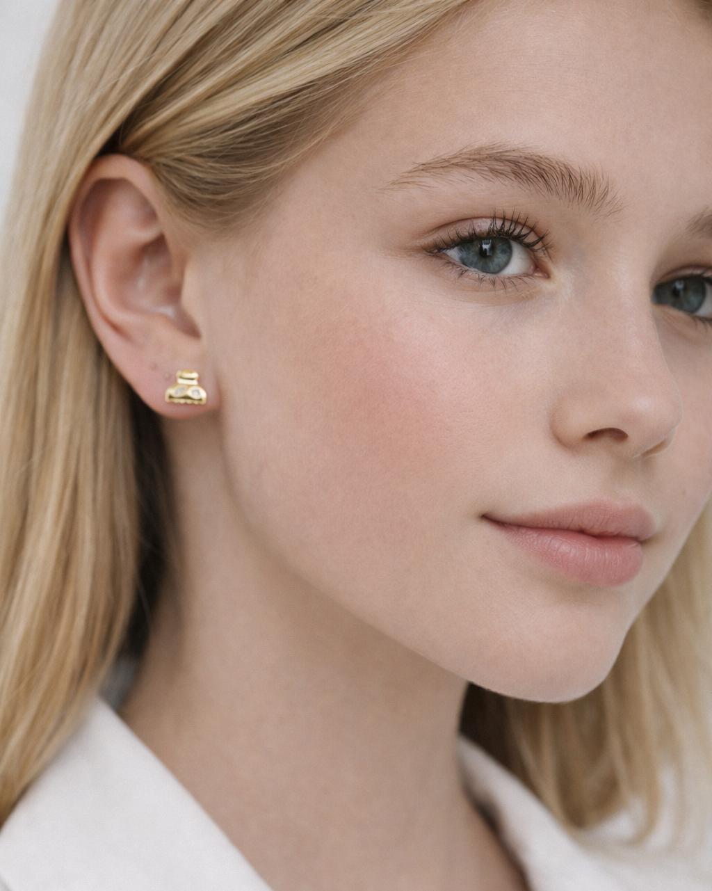 A close-up captures Lay It On Me Earrings resting on the lobe, their miniature gold handbag design clearly visible.