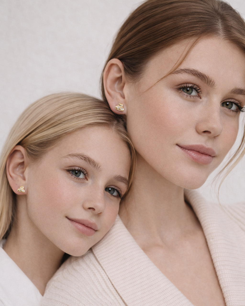 Two models both wear Lay It On Me Earrings, their whimsical gold handbag studs adding a playful detail.