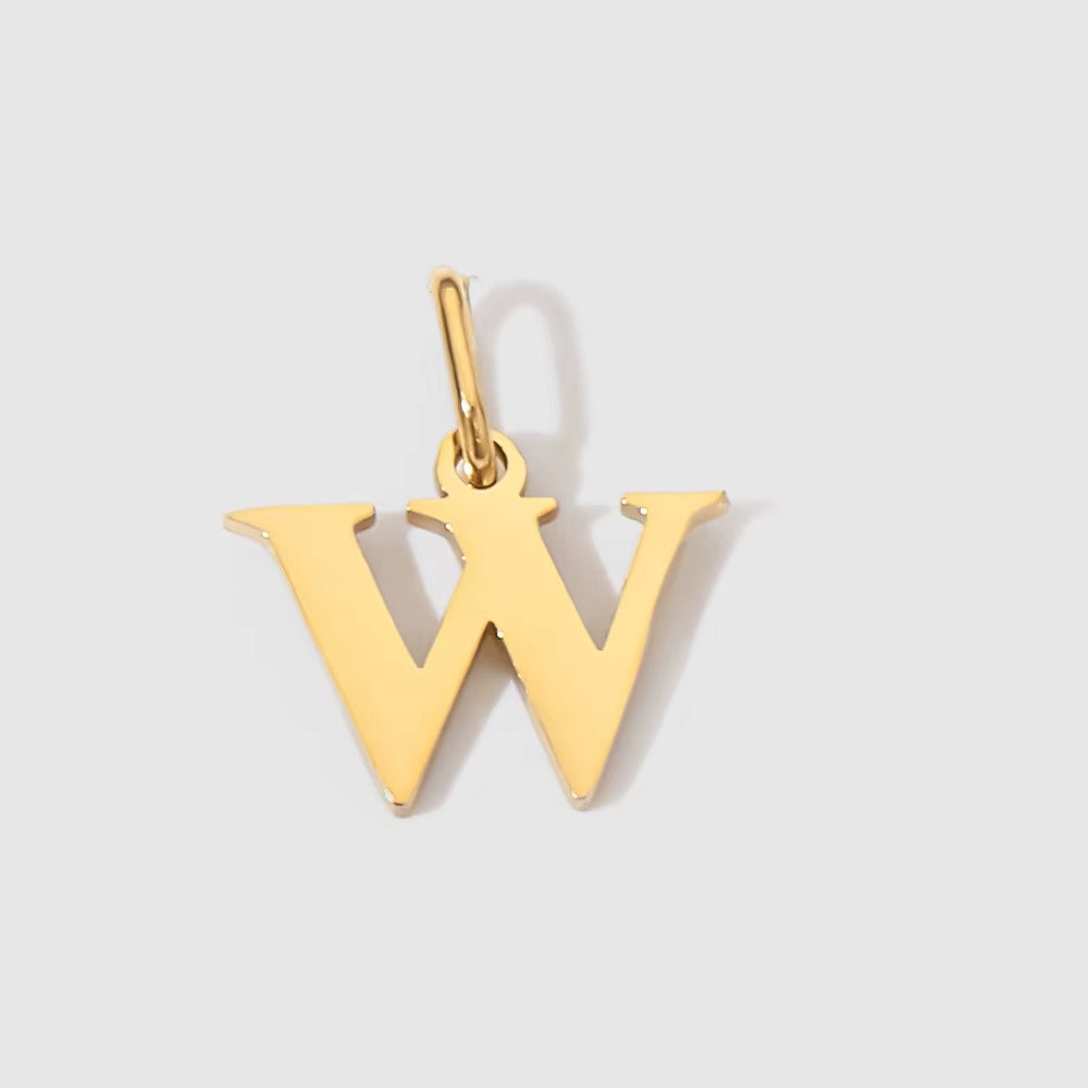 The Letter CHARM in lowercase w, a polished gold pendant in a serif w shape, shown in close-up on a light grey background.