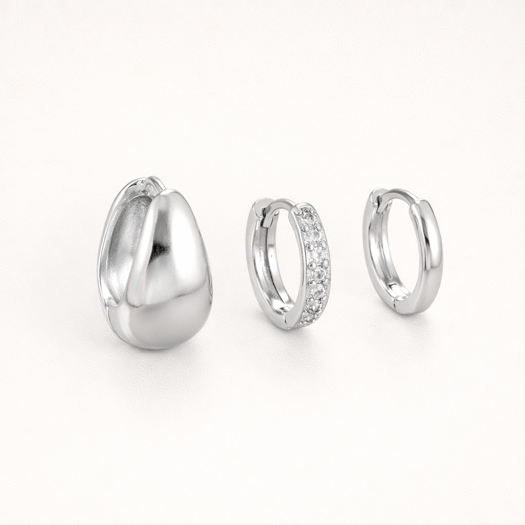 Lulu Set in silver tone, a chunky teardrop hoop, a pave hoop, and a plain hoop, shown together from an angle.