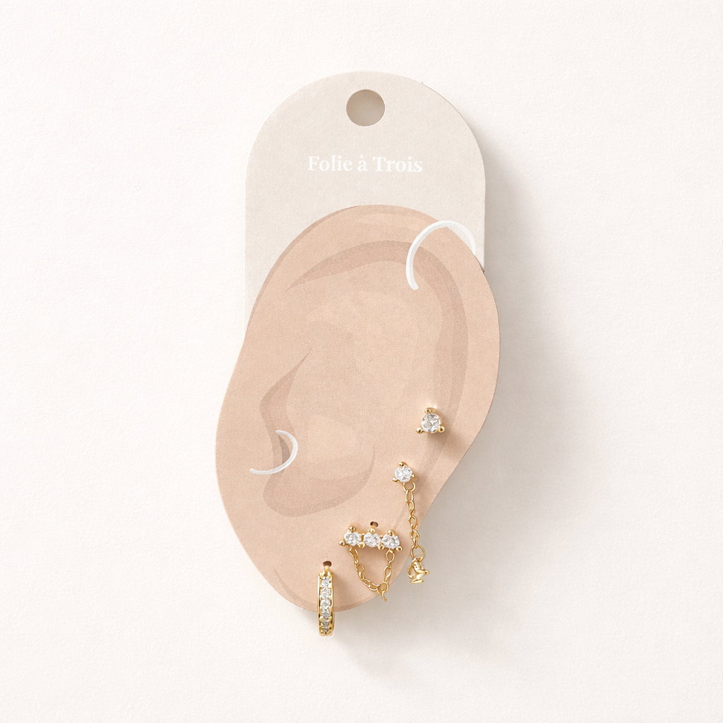 Illustrated Folie a Trois earring card showing the Maelys Set pieces arranged on an ear-shaped display.