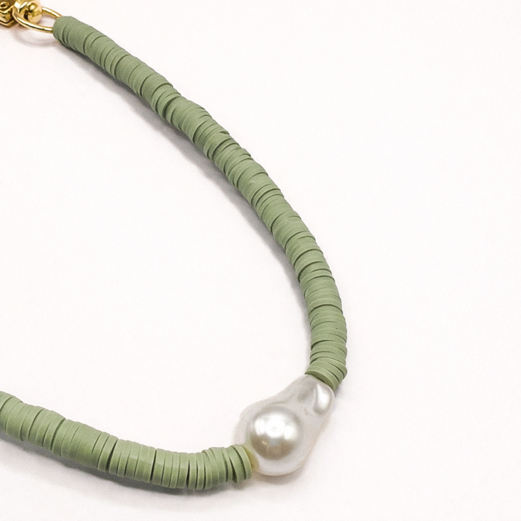 Close-up of a green heishi bead Melody SHORT PHONE CORD with a baroque pearl accent.