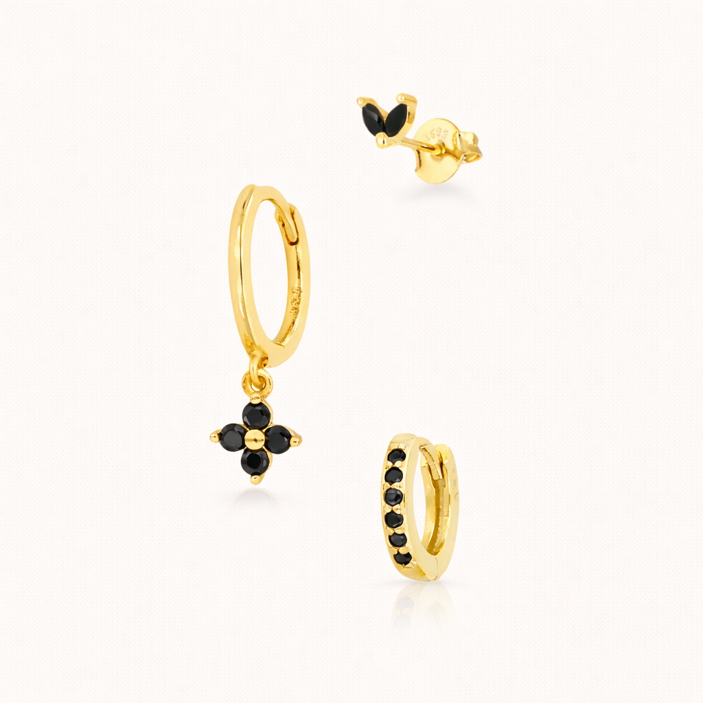 The New Perspective SET in gold with black onyx stones, showing the marquise stud, flower dangle hoop, and pavé hoop together in studio.