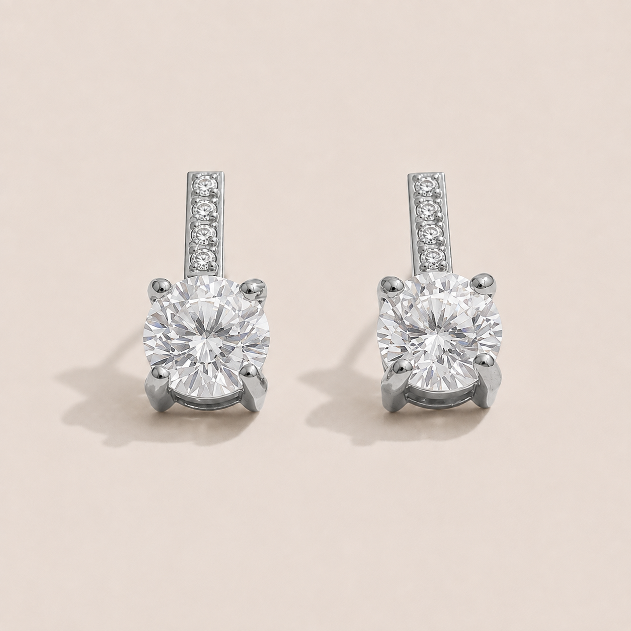 Silver stud earrings with a round white zirconia solitaire below a pavé bar on a cream backdrop — Folie à Trois Orbit EARRINGS