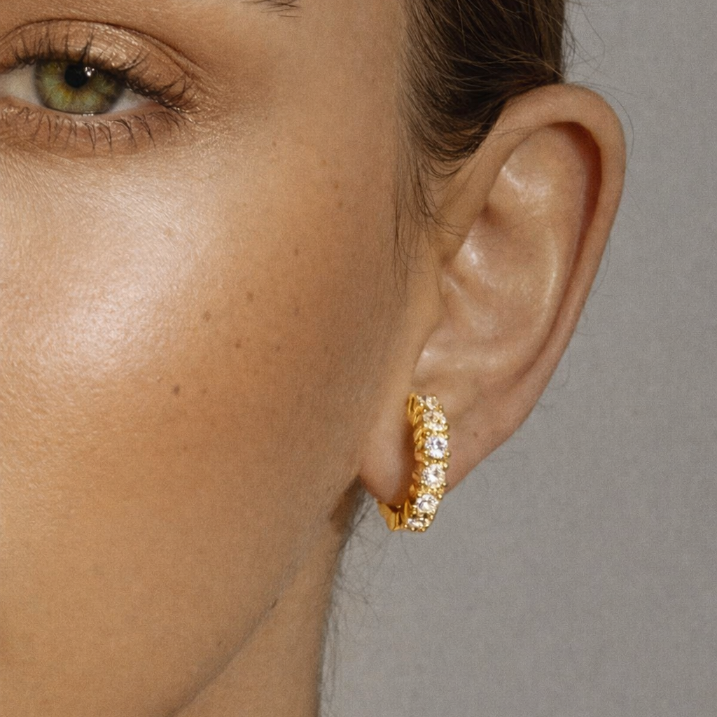 Retro Filter Earrings worn close on the ear, the gold crystal-studded huggie hoop catching light near the eye.
