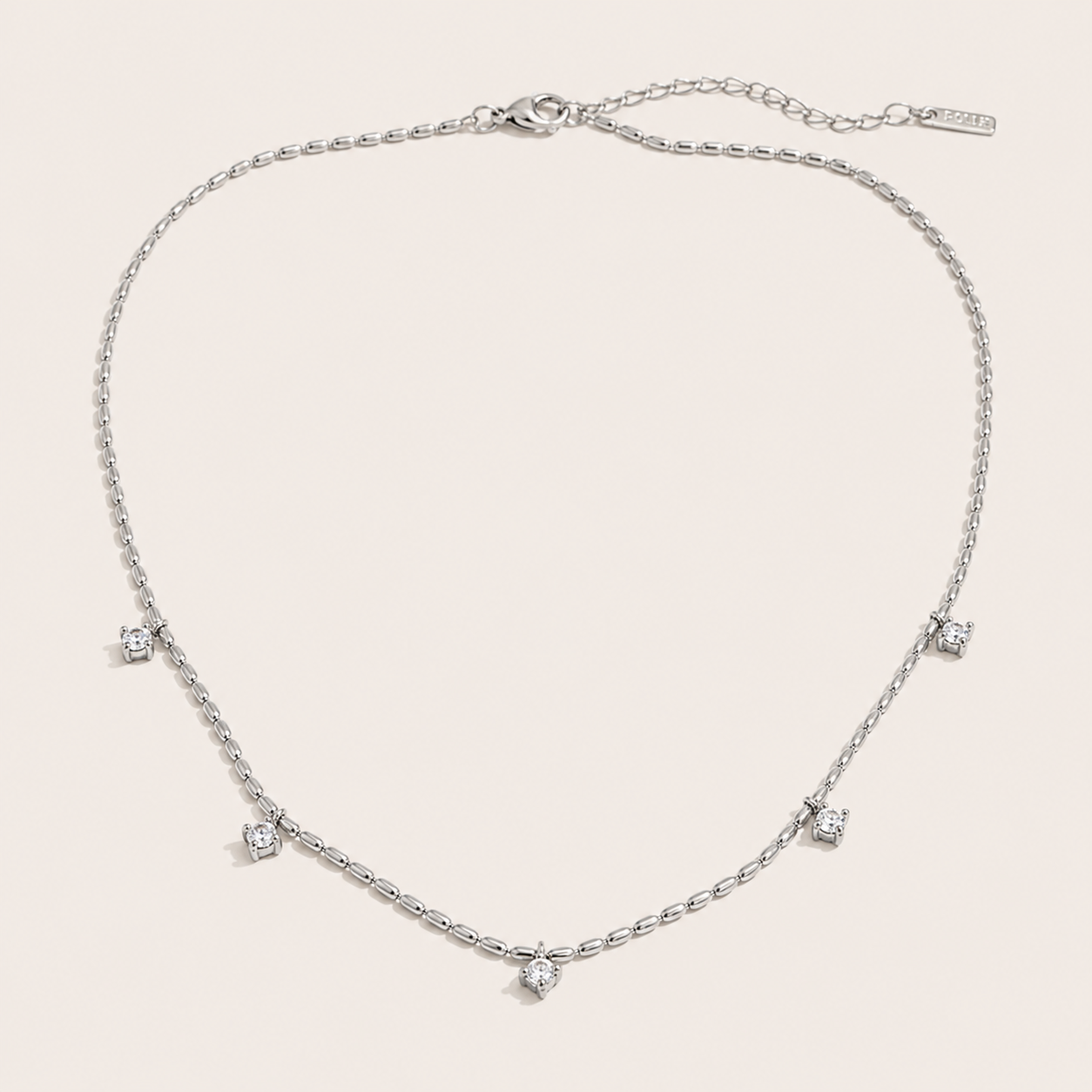 Silver station necklace with five round white zirconia charms spaced along a fine beaded chain — Folie à Trois Reverie NECKLACE.