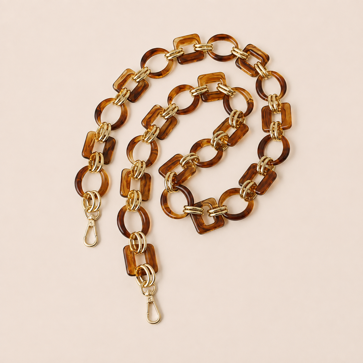 Amber tortoiseshell acrylic link phone chain with gold connectors coiled on cream — Folie à Trois Rowan long phone chain