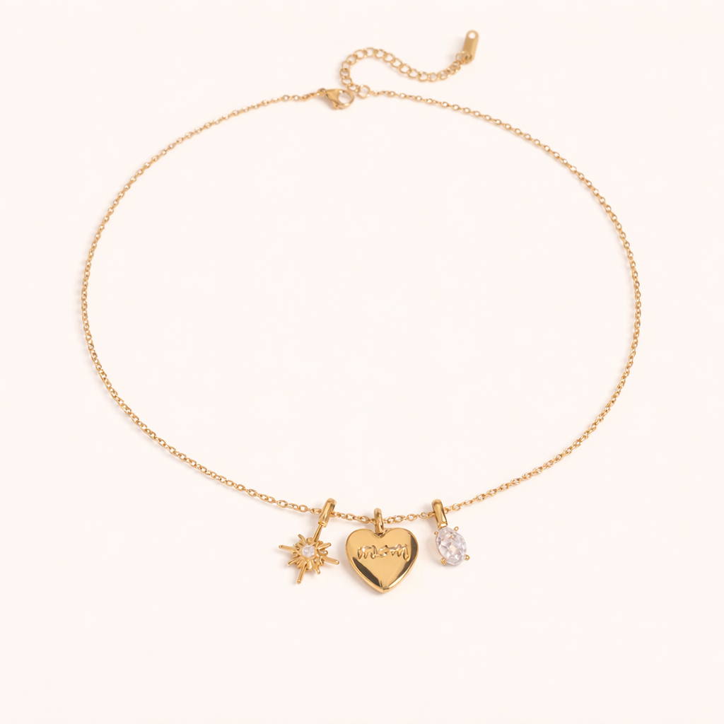The Soft Power NECKLACE laid flat, its gold star, engraved mom heart, and crystal charms shown on a fine chain with extender.