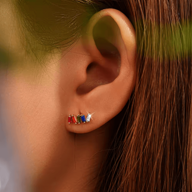 Worn along the ear, Solara Earrings show their curved row of colorful baguette stones catching the light.