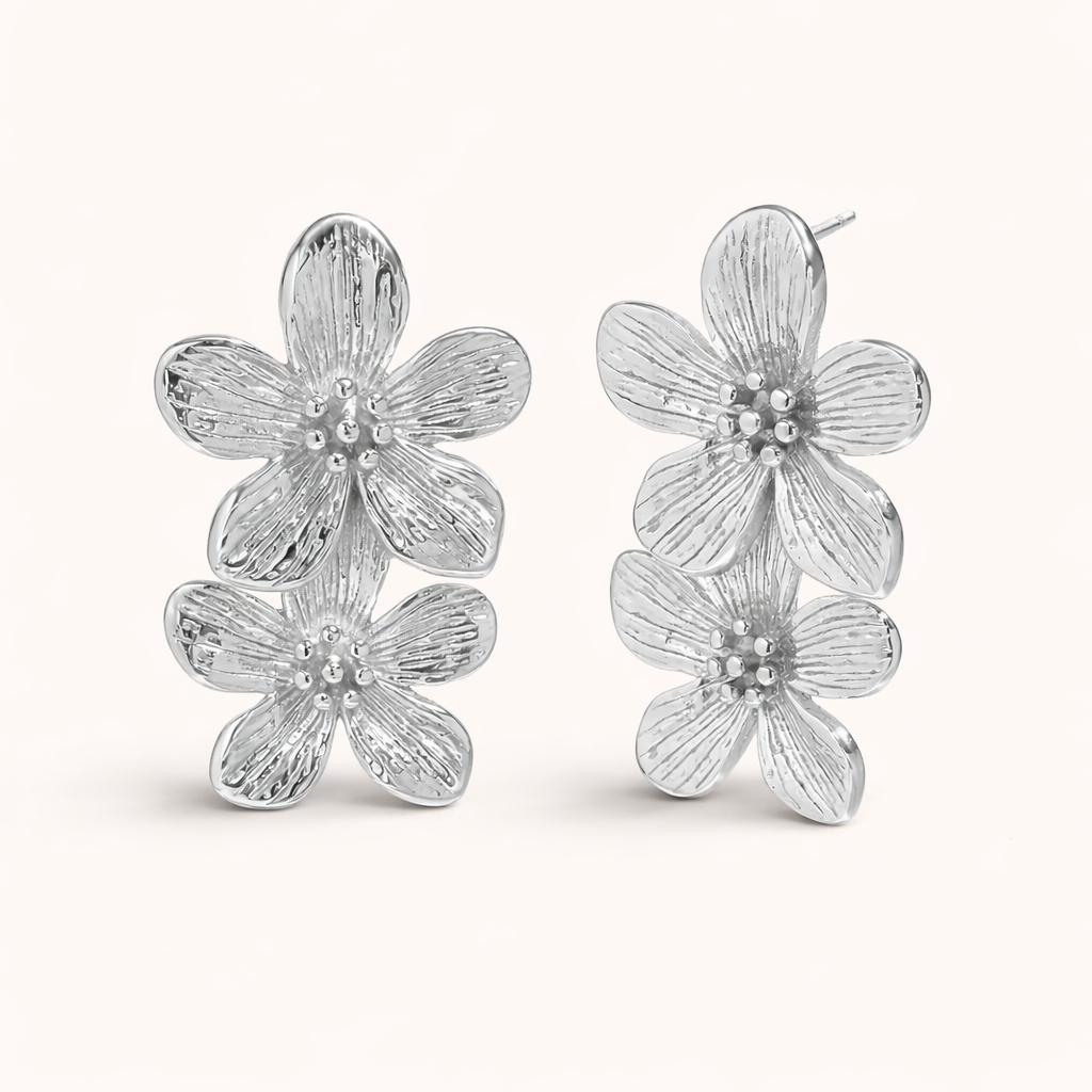 The Spring Bloom EARRINGS are shown in polished silver, with two textured flowers stacked along the ear.
