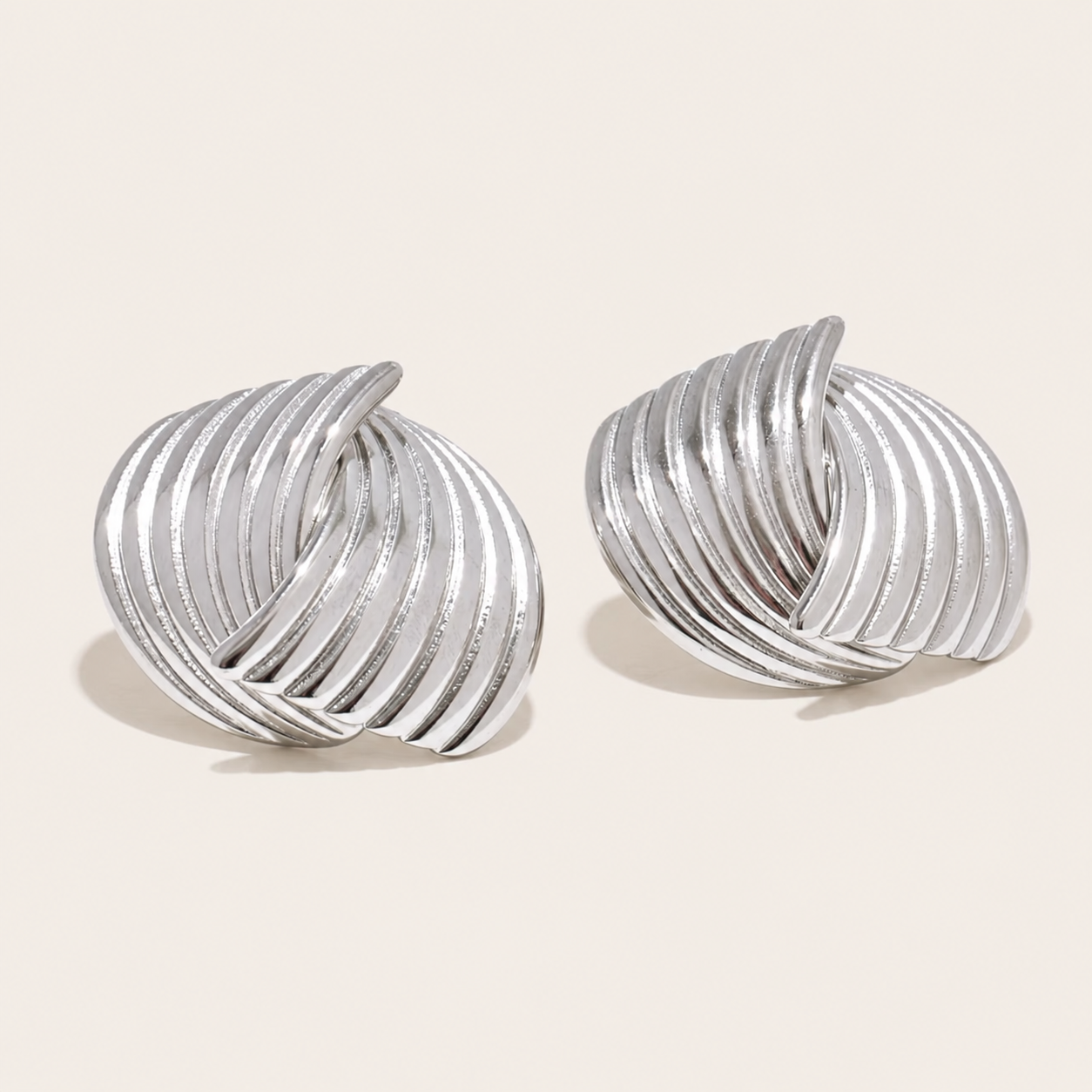 Silver ribbed swirl-textured knot stud earring with a bold sculptural spiral shape — Folie à Trois Sun Society EARRINGS.