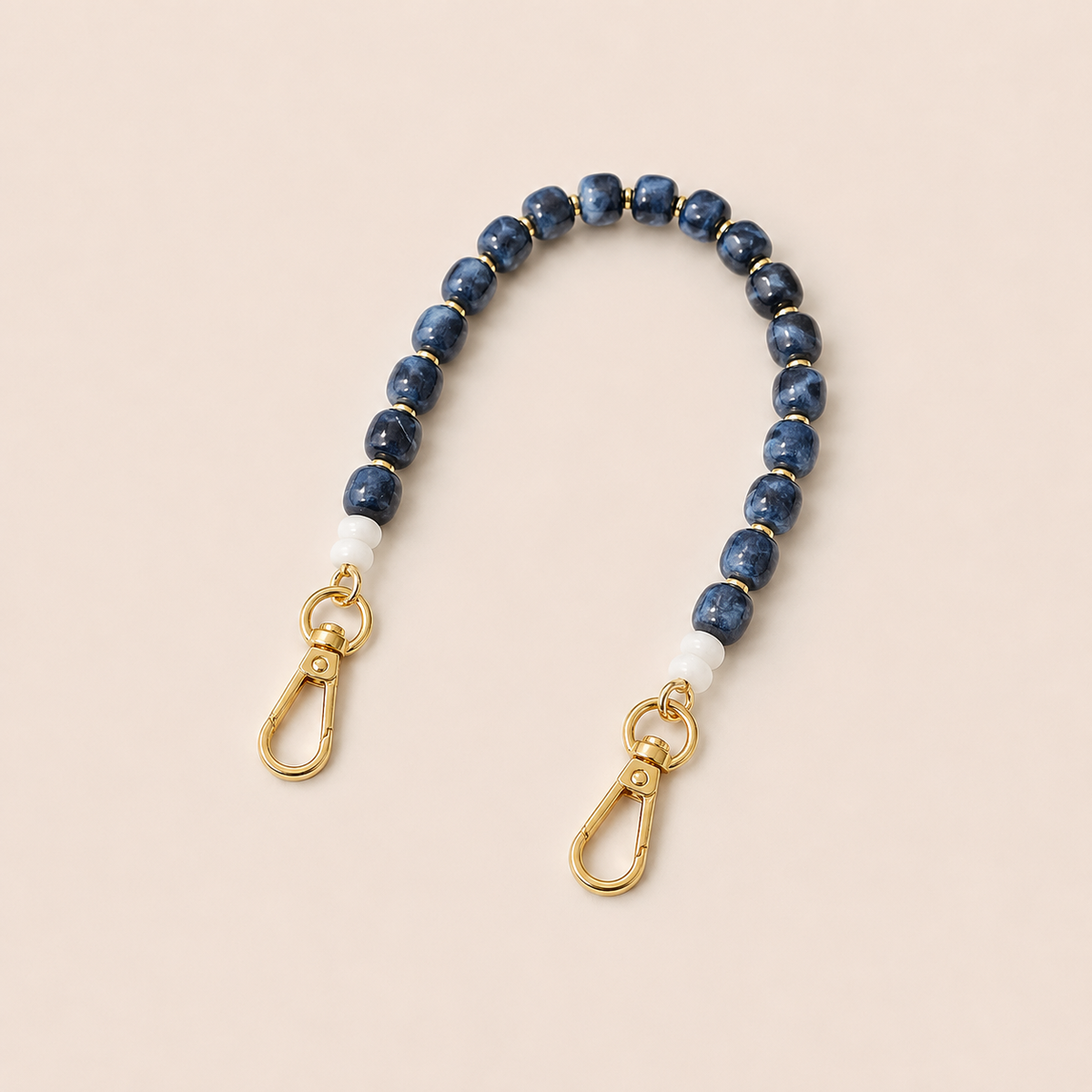 Blue marbled bead phone chain with white spacers and gold clasps on cream — Folie à Trois Teagan wholesale phone chain