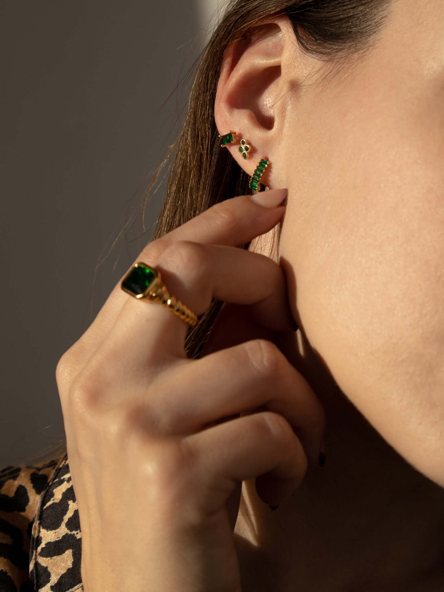 Vintage Vibes RING in the green stone colorway, worn stacked near the ear with small green stud earrings and a leopard-print top.