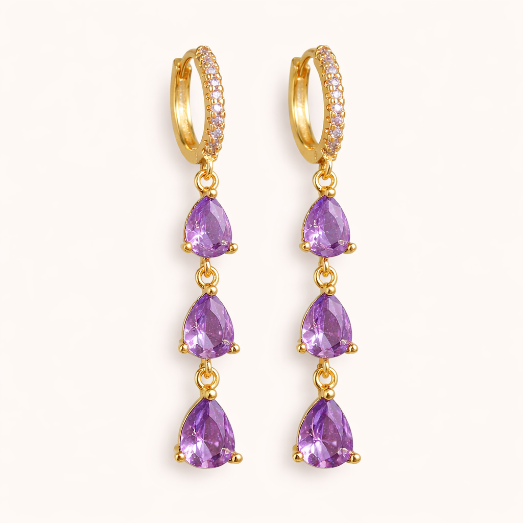Waterfall Earrings in gold with purple crystals, a pave huggie hoop dropping three graduated teardrop stones in a cascade.