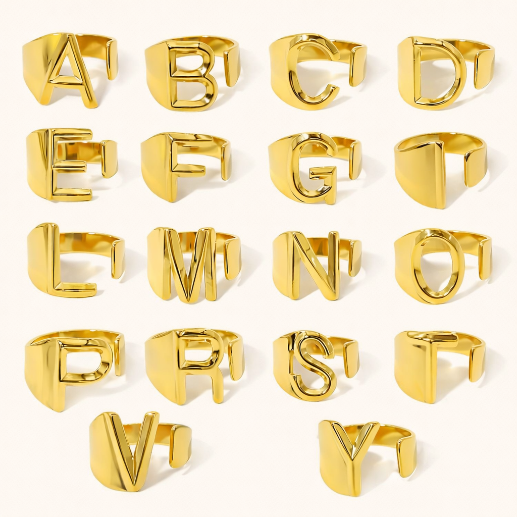 Full alphabet set of gold letter rings arranged in rows, each ring shaped as an open block letter — What Is Your Name RING.